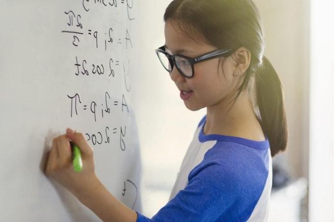 Child doing sums on whiteboard